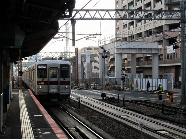 竹ノ塚駅に到着する東部10000系電車と建設中の下り急行線高架橋